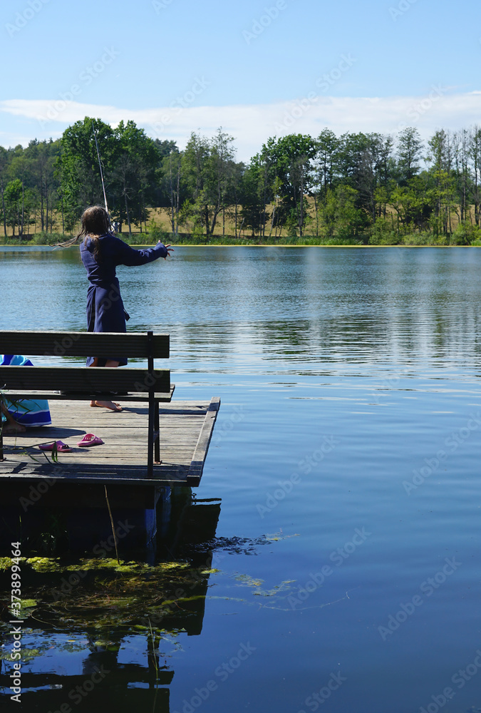 girl on the pier goes fishing with spinning girl on the pier goes fishing with spinning