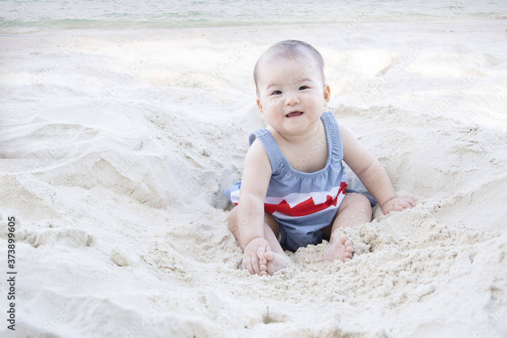 Asian Baby Smiling and Sitting on a Beach Asian Baby Smiling and Sitting on a Beach