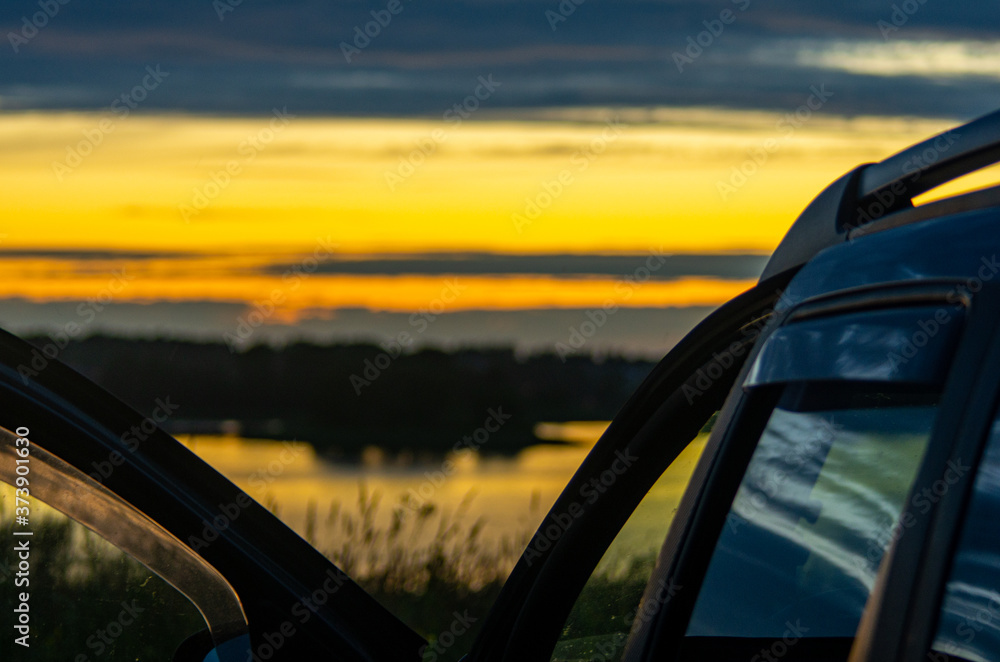 car at the lakeshore at the sunset