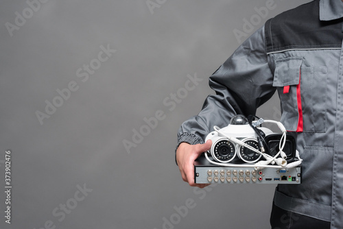 CCTV camera equipment in the engineer hands close up on gray background.