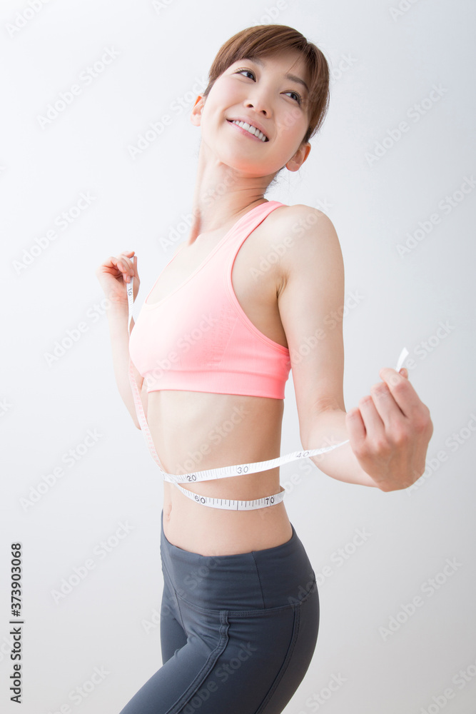 ウェストをメジャーで測る女性 ウェストをメジャーで測る女性