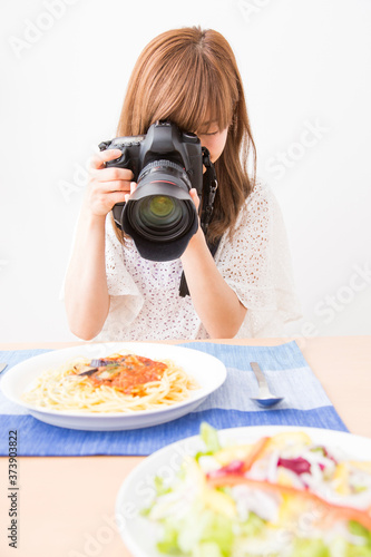 料理を撮影する女性カメラマン