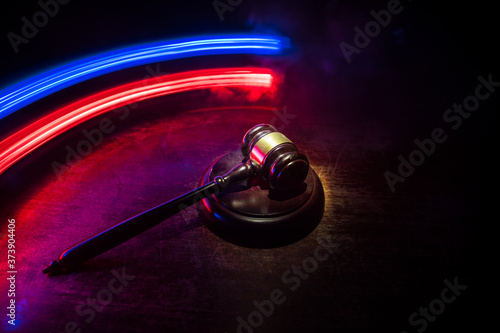 Law theme, mallet of the judge on wooden desk . Law gavel on dark foggy background with light. Selective focus