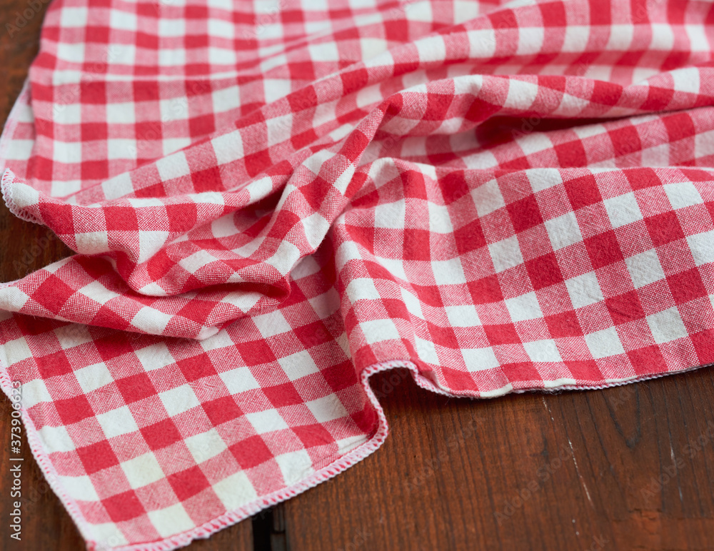 red-white textile kitchen towel on a brown wooden background from old boards red-white textile kitchen towel on a brown wooden background from old boards