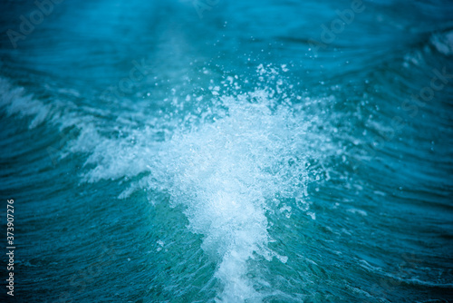 Background of water splash wave surface behind of fast moving motor speed boat