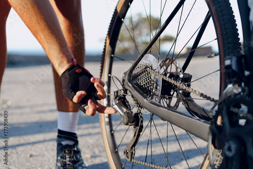 Cyclist man feet and bike wheel on coastal road