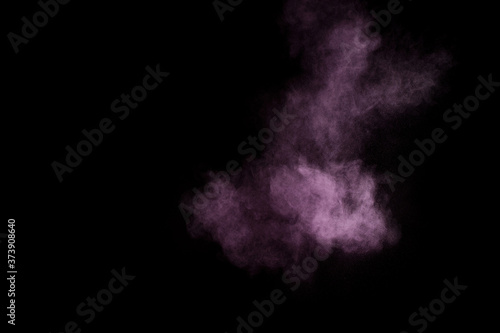 Purple powder explosion on black background. Colored powder cloud. Colorful dust explode. Paint Holi.