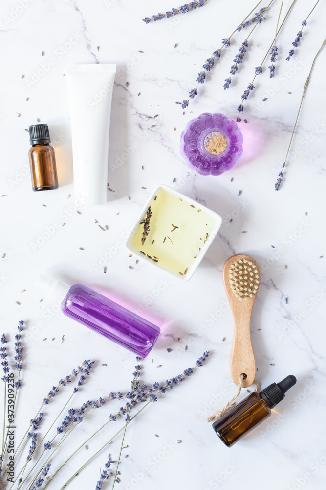 Variety of organic lavender cosmetics on white background top view.