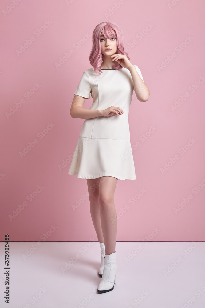 Beautiful girl with pink hair, hair coloring. Cute anime woman stands on a pink background in a short white dress. Colored hair, perfect hairstyle Beautiful girl with pink hair, hair coloring. Cute anime woman stands on a pink background in a short white dress. Colored hair, perfect hairstyle