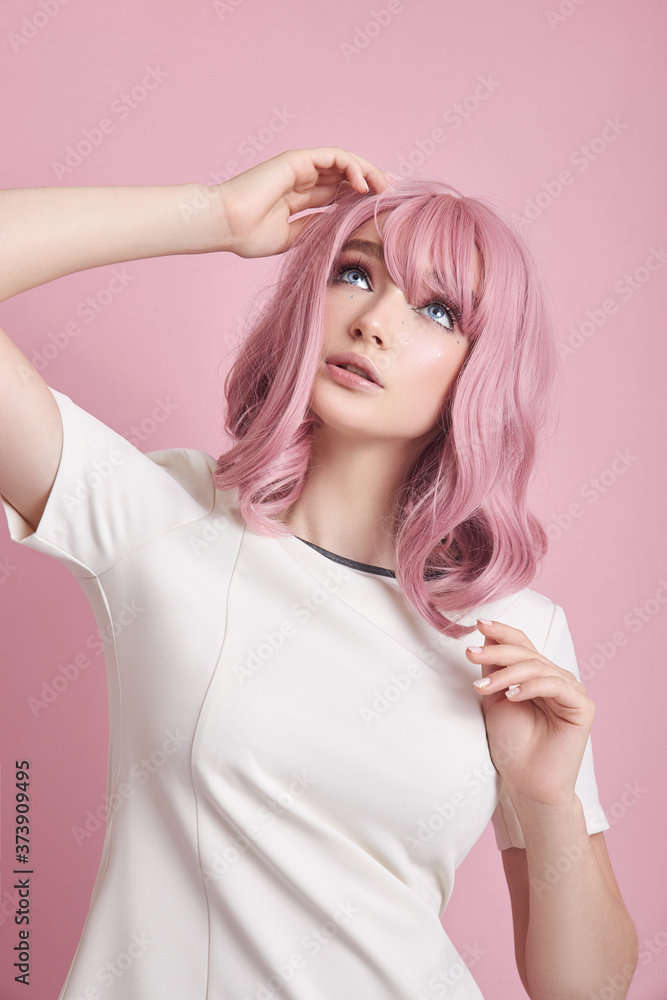 Cute girl with long pink hair, hair coloring. Beautiful woman on a pink background in a white dress. Colored hair, perfect hairstyle, beauty and care Cute girl with long pink hair, hair coloring. Beautiful woman on a pink background in a white dress. Colored hair, perfect hairstyle, beauty and care