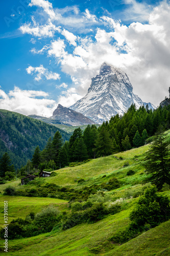 Konstfotografi Vertical scenic view of the Matterhorn mountain summit with snow clouds blue sky