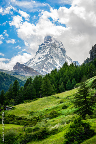 Fotografie Vertical scenic view of the Matterhorn mountain summit with snow clouds blue sky