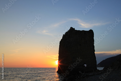 Photo of a beautiful rock in the sea at sunset © tanor27
