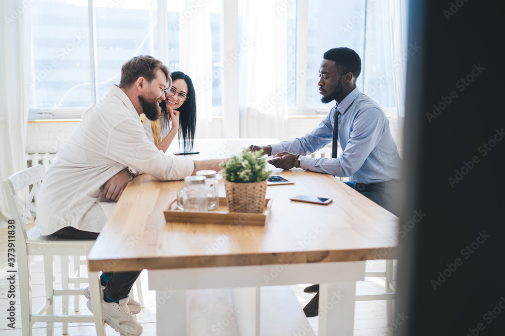 Ethnic real estate agent making deal with joyful couple
