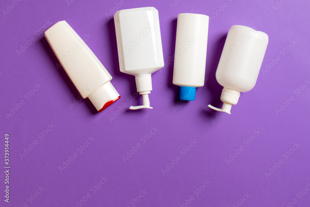 Set of White Cosmetic containers isolated on colored background, top view with copy space. Group of plastic bodycare bottle containers with empty space for you design Set of White Cosmetic containers isolated on colored background, top view with copy space. Group of plastic bodycare bottle containers with empty space for you design