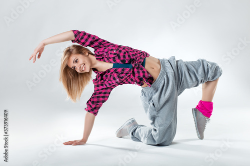 Young beautiful blonde girl dancing on a white studio background