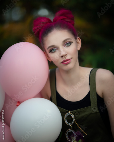 Portrait of a cheerful little girl with pink hair and festive balls © Evgeniya Fedorova