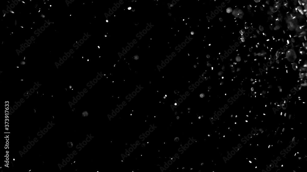 Dust particles sparkling on black background with white light bokeh effect