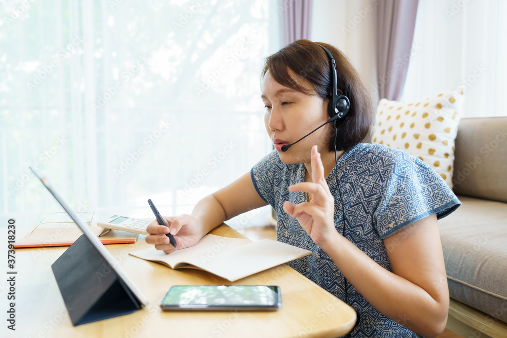 Asian woman aged 30-35 years using tablet, watching lesson online course communicate by conference video call from home, e-learning education concept