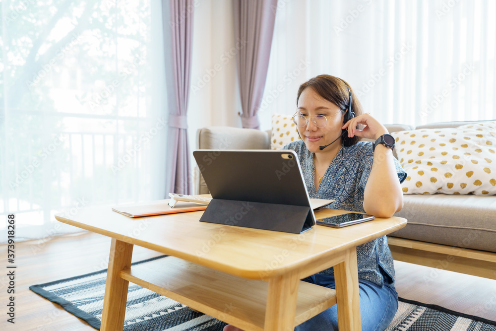 Asian woman aged 30-35 years using tablet, watching lesson online course communicate by conference video call from home, e-learning education concept Asian woman aged 30-35 years using tablet, watching lesson online course communicate by conference video call from home, e-learning education concept