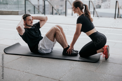 happy young couple handsome brunette man and beautiful woman in sportswear warming up before street workout, healthy fit lifestyle photo