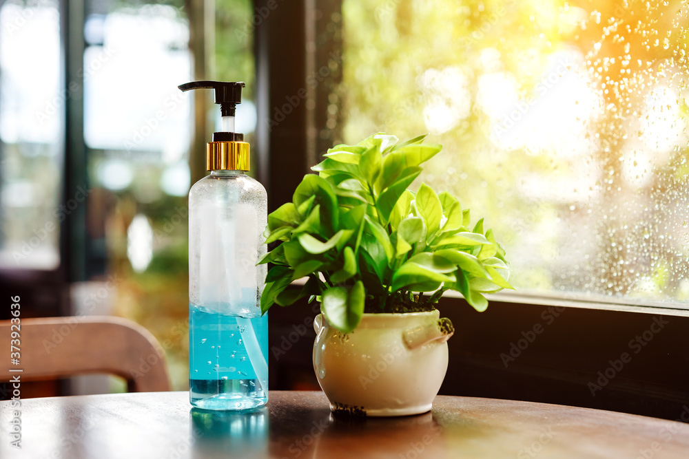 Blue alcohol gel bottle for hand cleaning to prevent the spreading of the Coronavirus (Covid-19), Placed on table to service for customers in the cafe. Healthcare concept. New normal lifestyle Blue alcohol gel bottle for hand cleaning to prevent the spreading of the Coronavirus (Covid-19), Placed on table to service for customers in the cafe. Healthcare concept. New normal lifestyle
