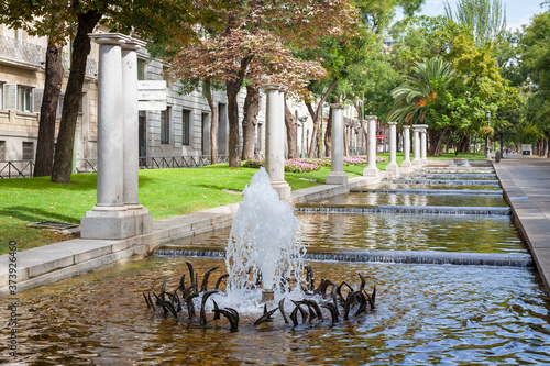 Street with a fountain and Architecture of Madrid in Spain in autumn, September