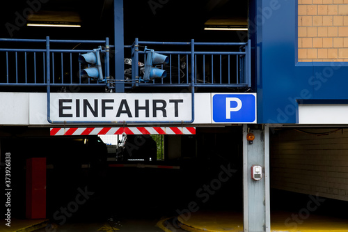 Entrance of a car parking garage with signal lights and the sign "Einfahrt"