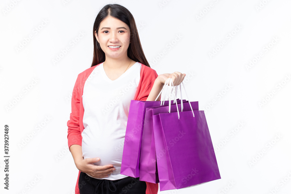 Portait happy young pregnant woman with shopping bags and touching her big belly isolated on white background. Pregnancy shopping concept. Portait happy young pregnant woman with shopping bags and touching her big belly isolated on white background. Pregnancy shopping concept.