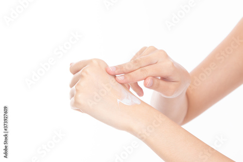 Closeup beautiful young woman hands applying moisturizing hand cream on skin isolated on white background.