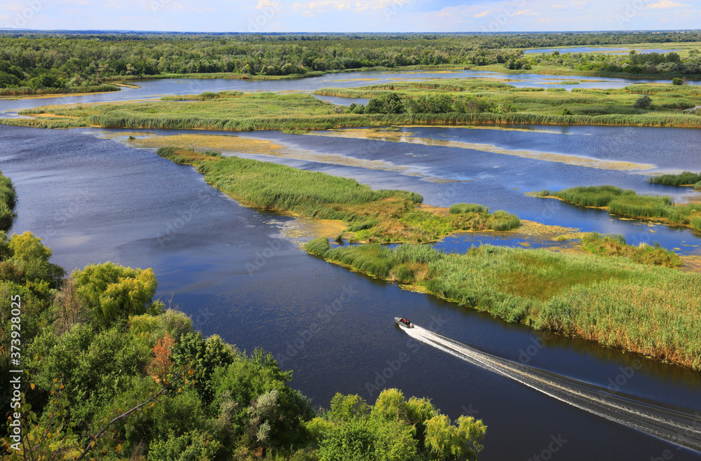 Motor boat floats between the green islands