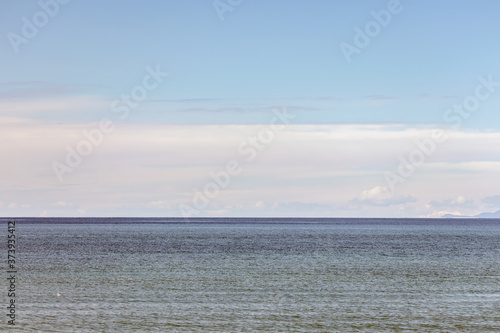 Horizon ocean view with clouds and blue sky