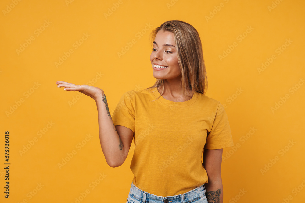 Image of nice delighted woman holding and showing copyspace Image of nice delighted woman holding and showing copyspace