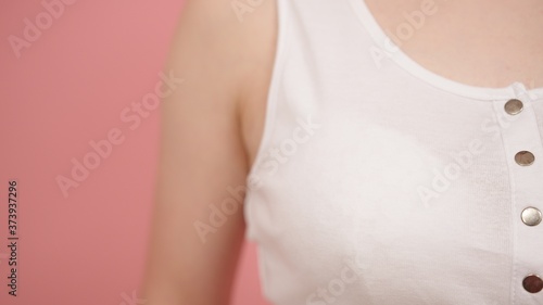 Close up shot, woman in the white shirt isolated on the pink background. Pink october concept. High quality photo