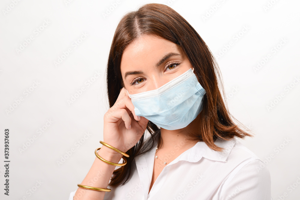 portrait of a beautiful young caucasian woman smiling and wearing a white shirt business wear and surgical mask on a white background portrait of a beautiful young caucasian woman smiling and wearing a white shirt business wear and surgical mask on a white background