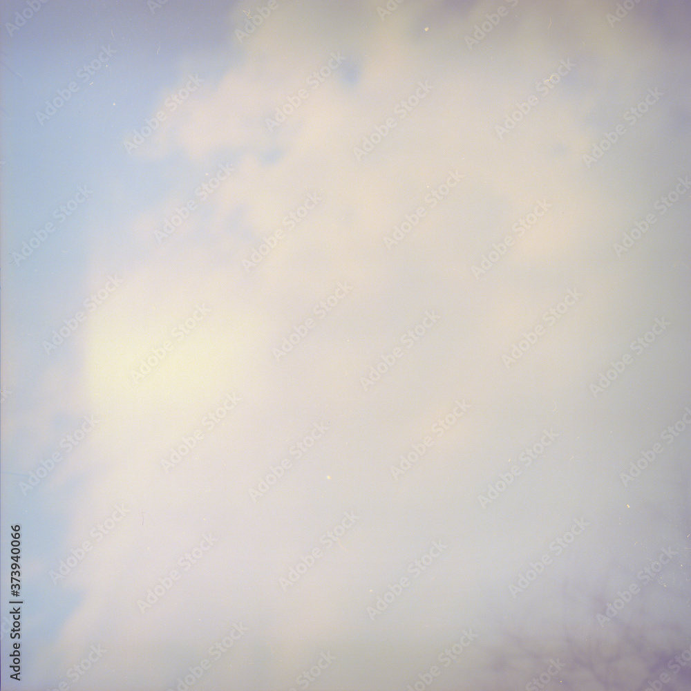 Grunge image of sky with a cloud on grainy film texture