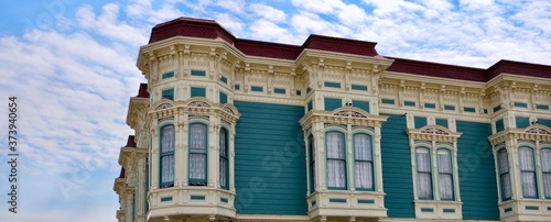 Closeup of traditional house in the city of Ferndale in Humboldt County, California, USA, famous for its Victorian architecture, a sunny day with blue sky and clouds in summer, space for text photo