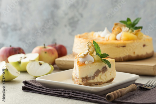 Caramel apple pear cheesecake. Close up side view stone kitchen table, side view. Autumn dessert. Woman decorated apple cake