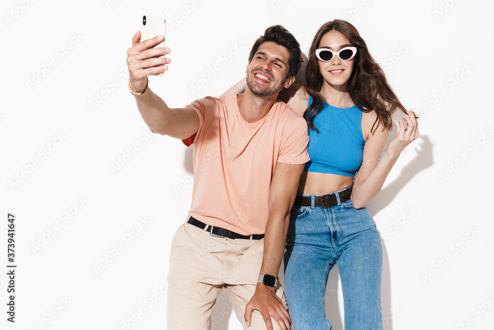 Image of attractive happy couple smiling while selfie on smartphone Image of attractive happy couple smiling while selfie on smartphone