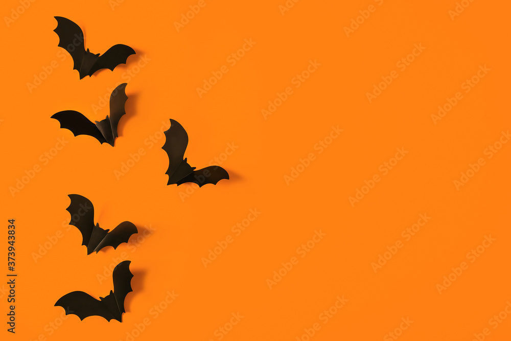 Cartoon halloween background black bats on orange backdrop. Bright holiday backdrop for your design. Dark and moody background. Place for text. Cartoon halloween background black bats on orange backdrop. Bright holiday backdrop for your design. Dark and moody background. Place for text.