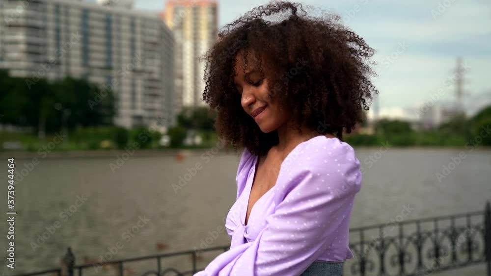 young cheerful black woman is walking in city embankment and dancing, happy townswoman young cheerful black woman is walking in city embankment and dancing, happy townswoman