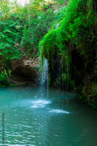 Fototapeta Naklejka Na Ścianę i Meble -  Jungle landscape with flowing turquoise water of a cascading waterfall. Burbun waterfall, Ukraine.