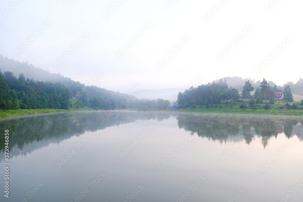Beautiful view of Krempna reservoir on magical misty morning. Reflections in the water. Low Beskids Mountains, Poland