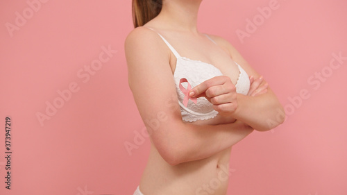 Woman in bra with pink ribbon, breast cancer survivor, pink october, awareness month. High quality photo © CameraCraft