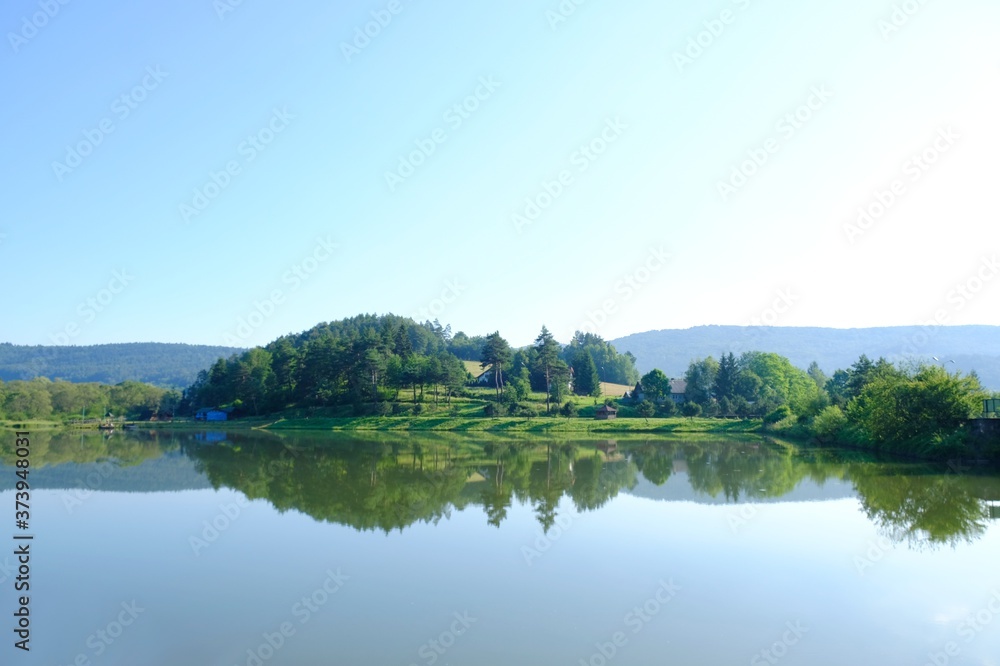Beautiful view of Krempna reservoir on magical sunny morning. Reflections in the water. Low Beskids Mountains, Poland