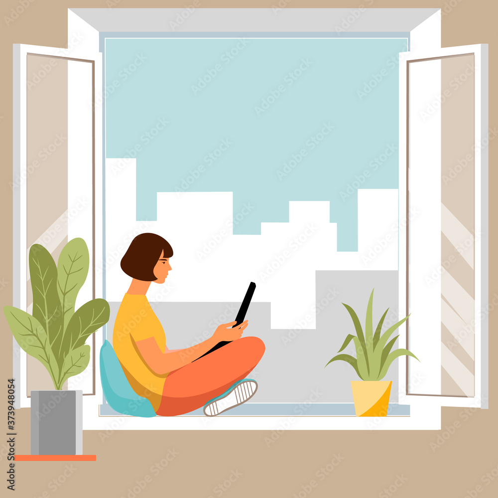 Fototapeta premium The girl is reading a book, sitting on the sill of an open window .