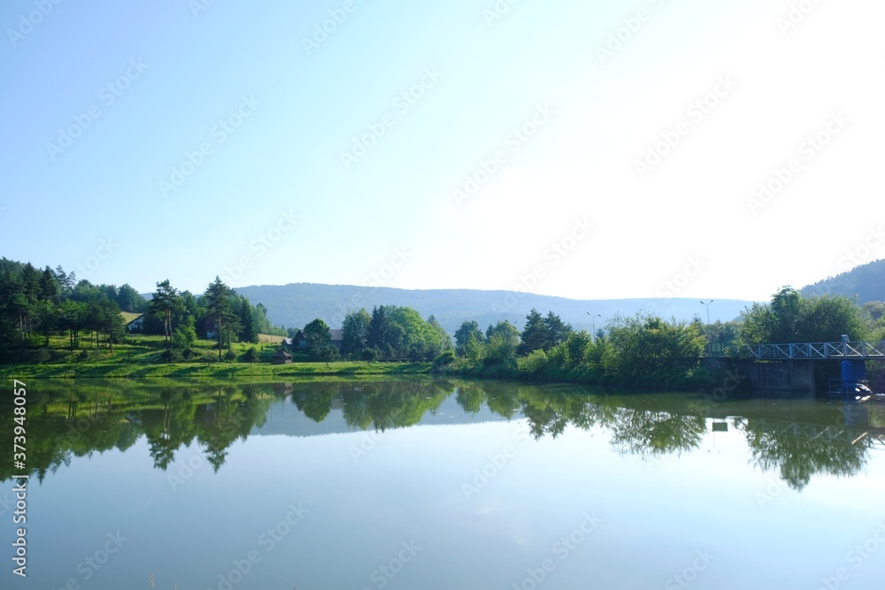 Beautiful view of Krempna reservoir on magical sunny morning. Reflections in the water. Low Beskids Mountains, Poland