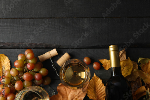Composition with wine and grape on wooden background, top view