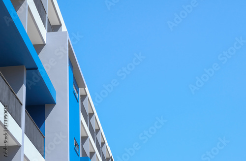 Modern building facade. Perspective view of exterior blue and grey color with clear sky background, copy space.