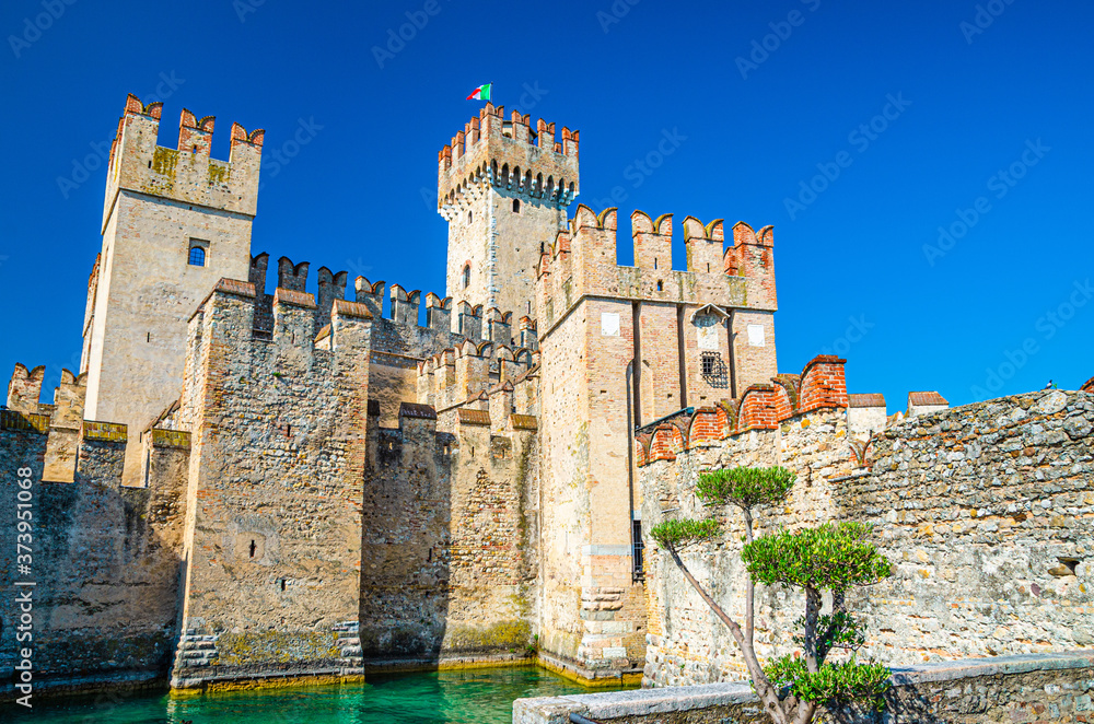 Scaligero Castle Castello di Sirmione fortress from Scaliger era in historical center of Sirmione town on Garda lake, medieval castle with stone towers and brick walls, Lombardy, Northern Italy